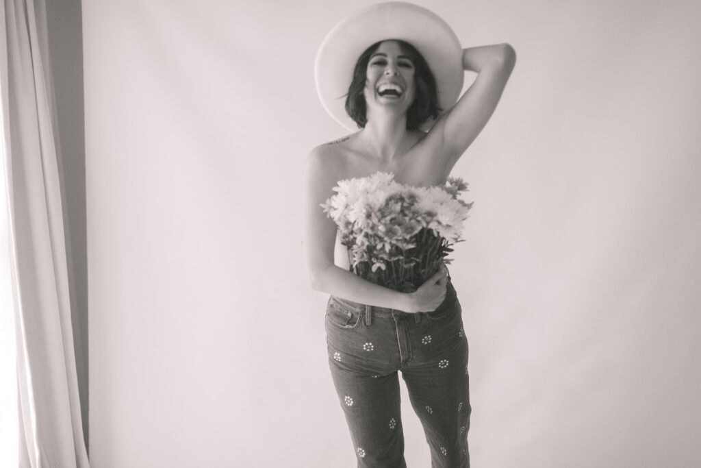 black and white blurry motion photo of a woman laughing holding flowers