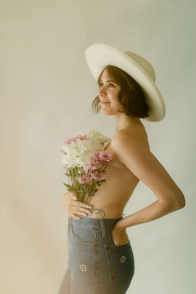 Woman smiles while holding a bouquet of flowers over her chest