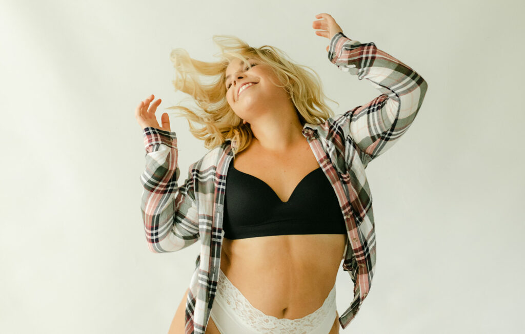 Woman dances in her underwear & a flannel shirt in Franklin, Tn photography studio