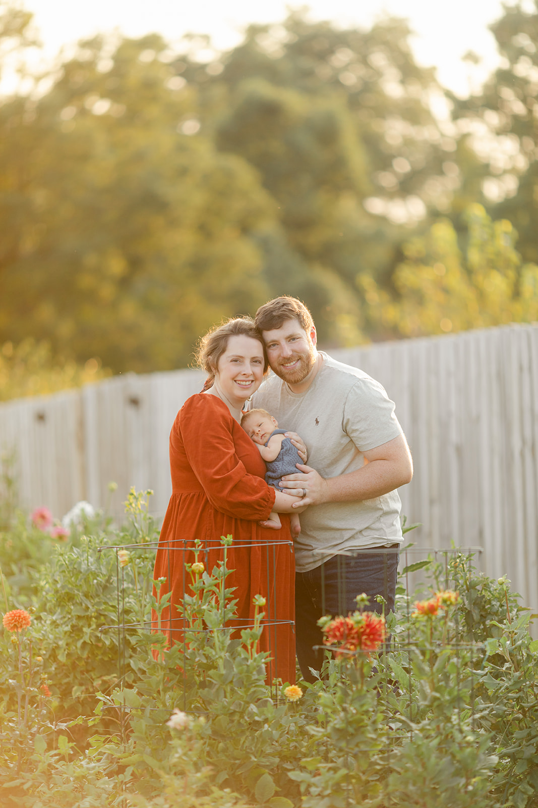 parents with newborn baby boy backyard photo