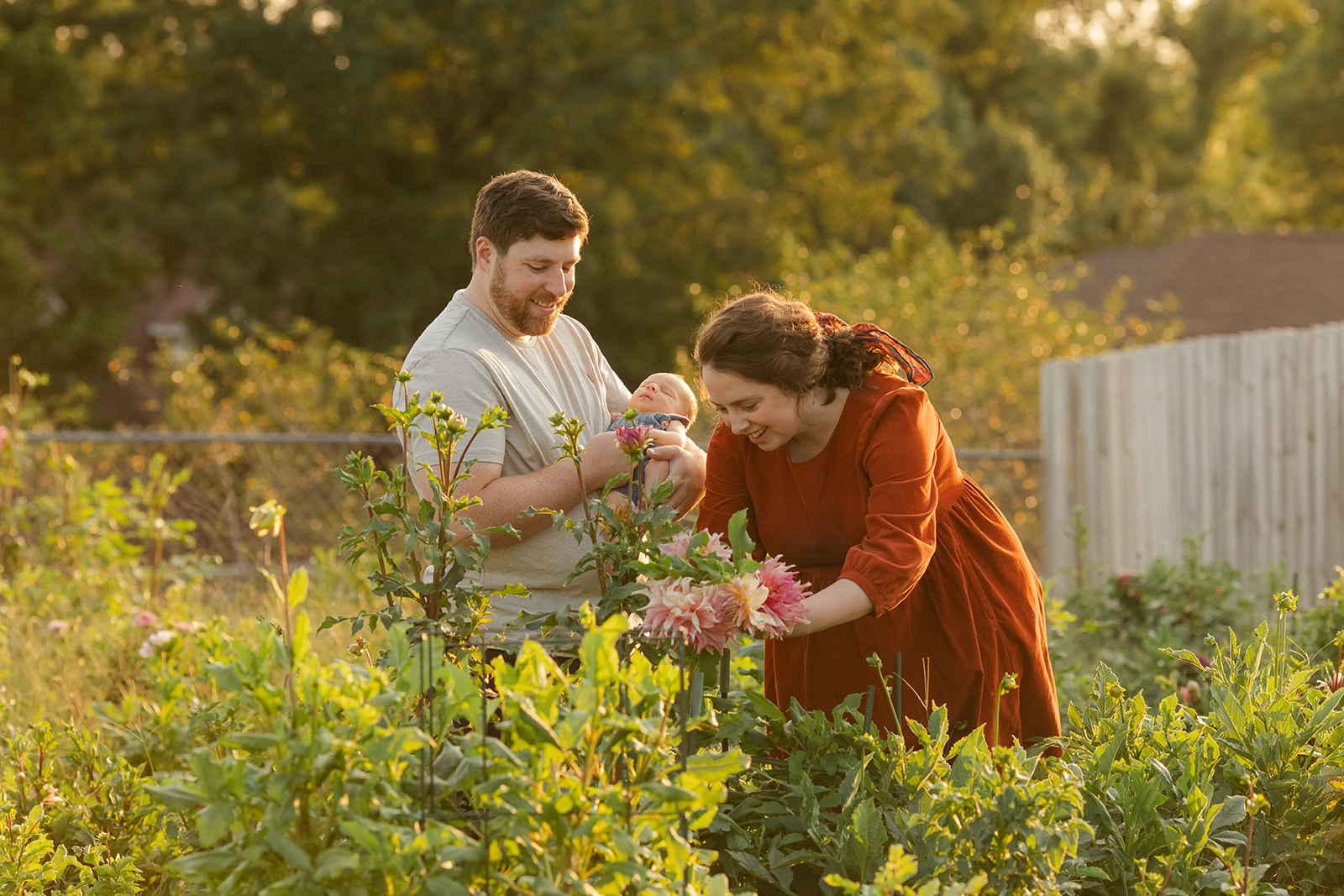 parents with newborn baby boy backyard photo