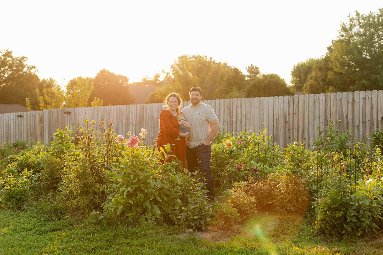 parents with newborn baby boy backyard photo