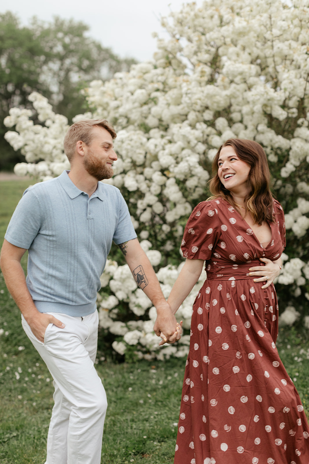couple during maternity photos with flower bush