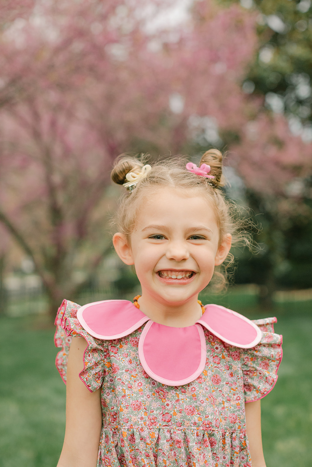 smiling little girl surrounded by cherry blossoms