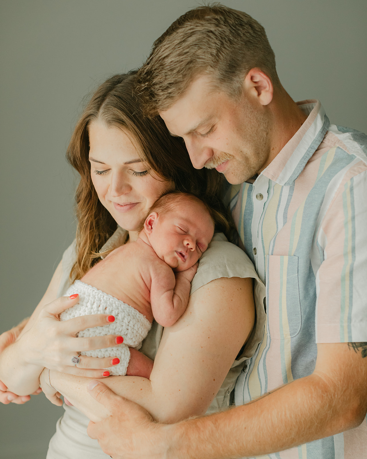 parents and sleepy newborn baby boy