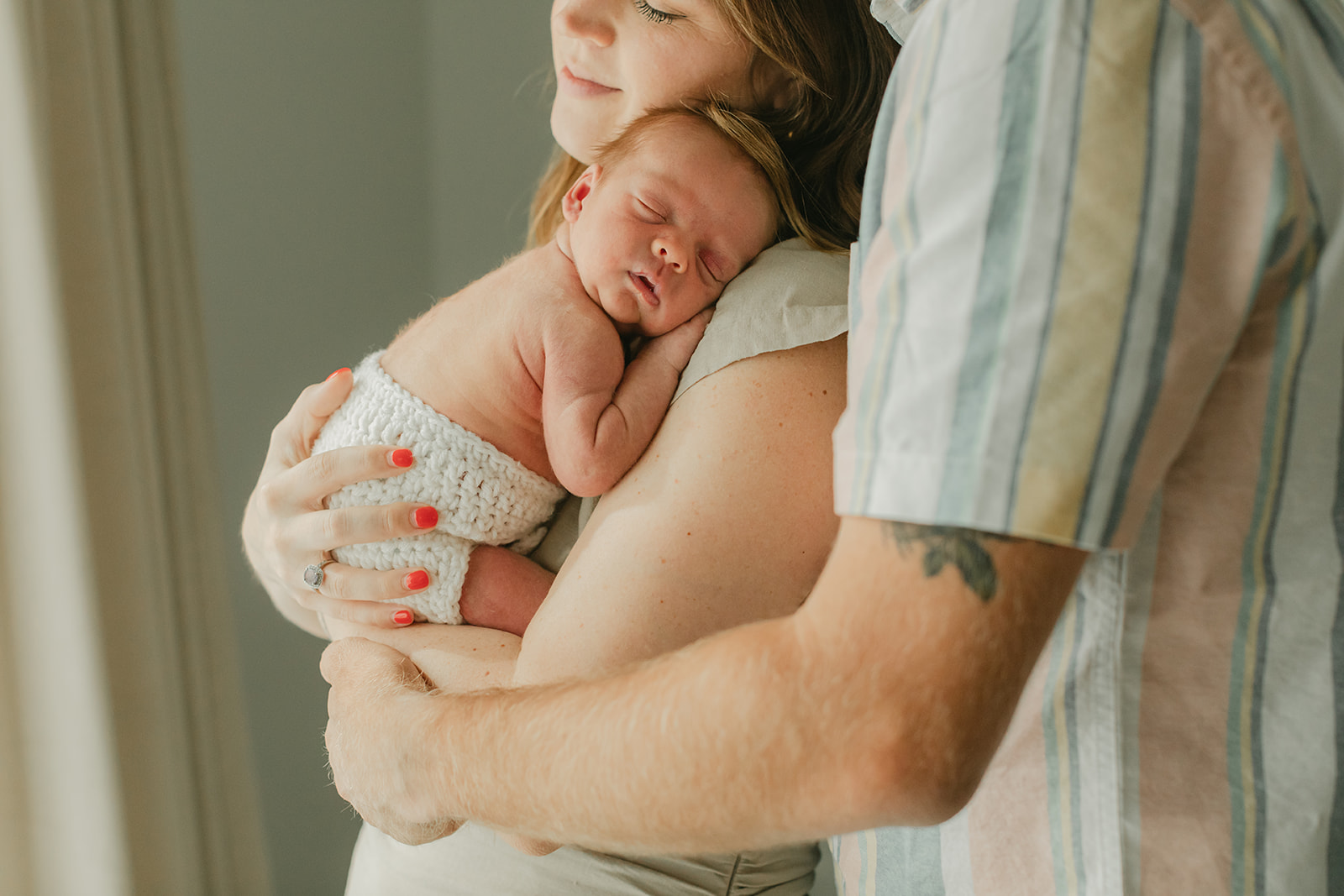 parents and sleepy newborn baby boy