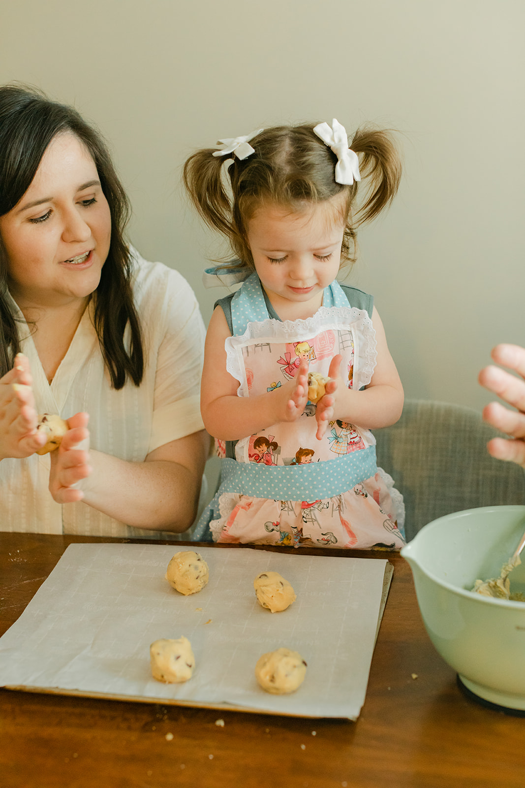 little girl baking cookies with parents