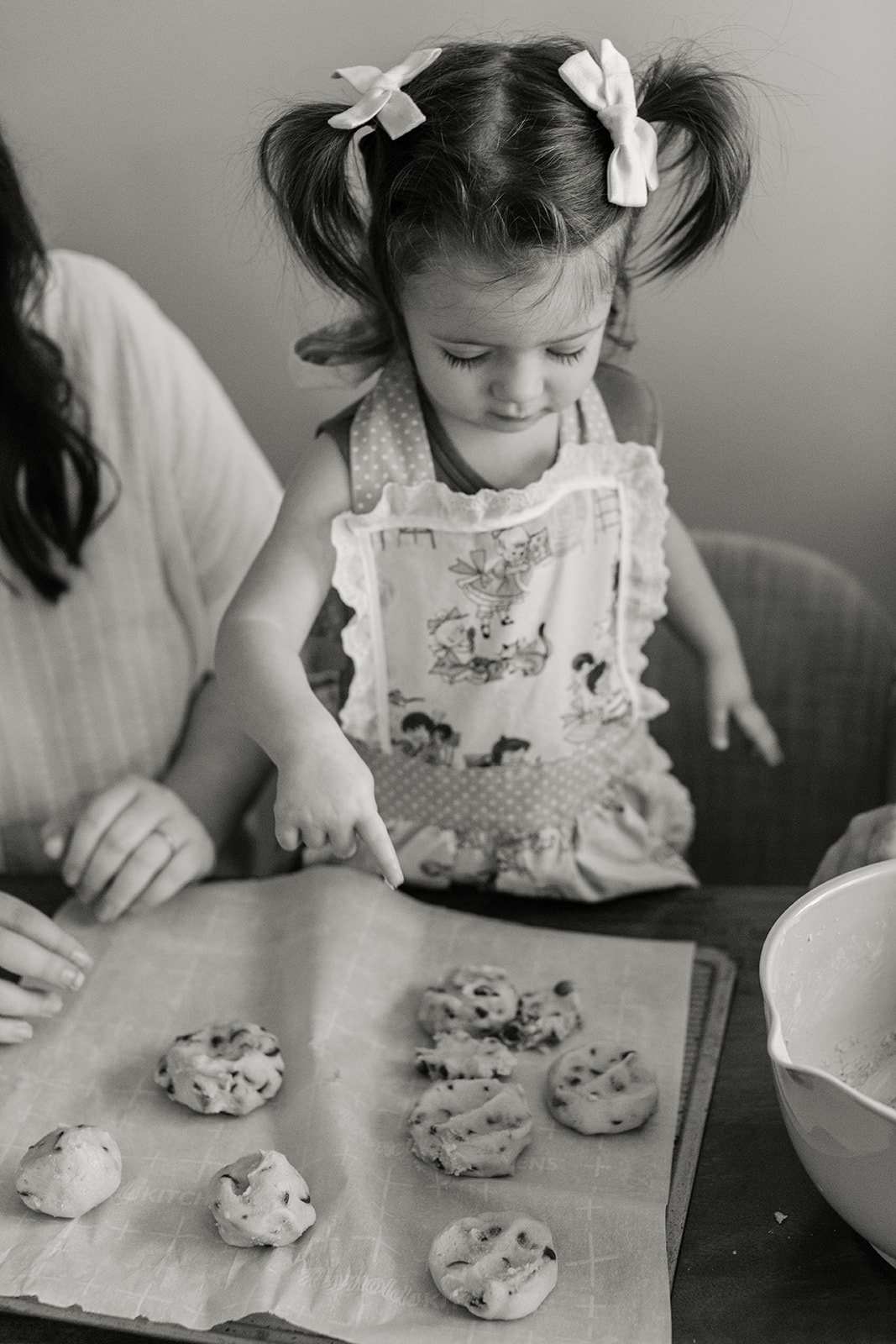little girl baking cookies with parents