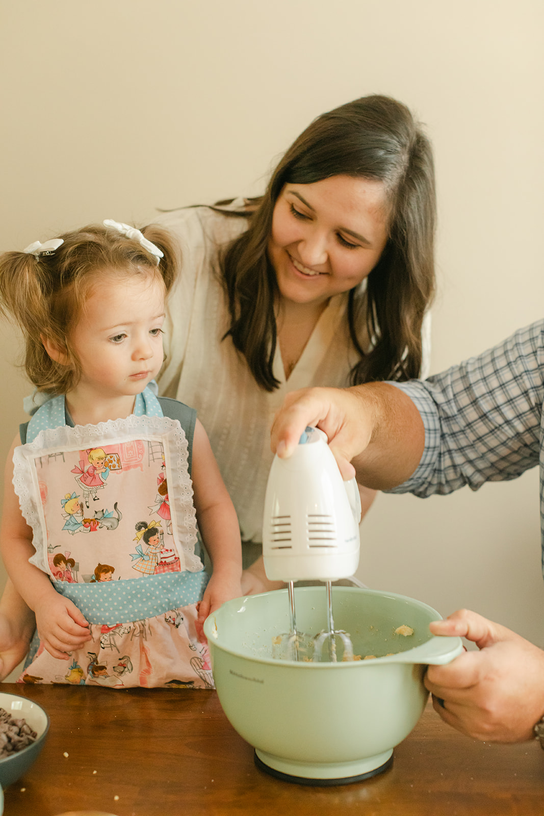 little girl baking with parents