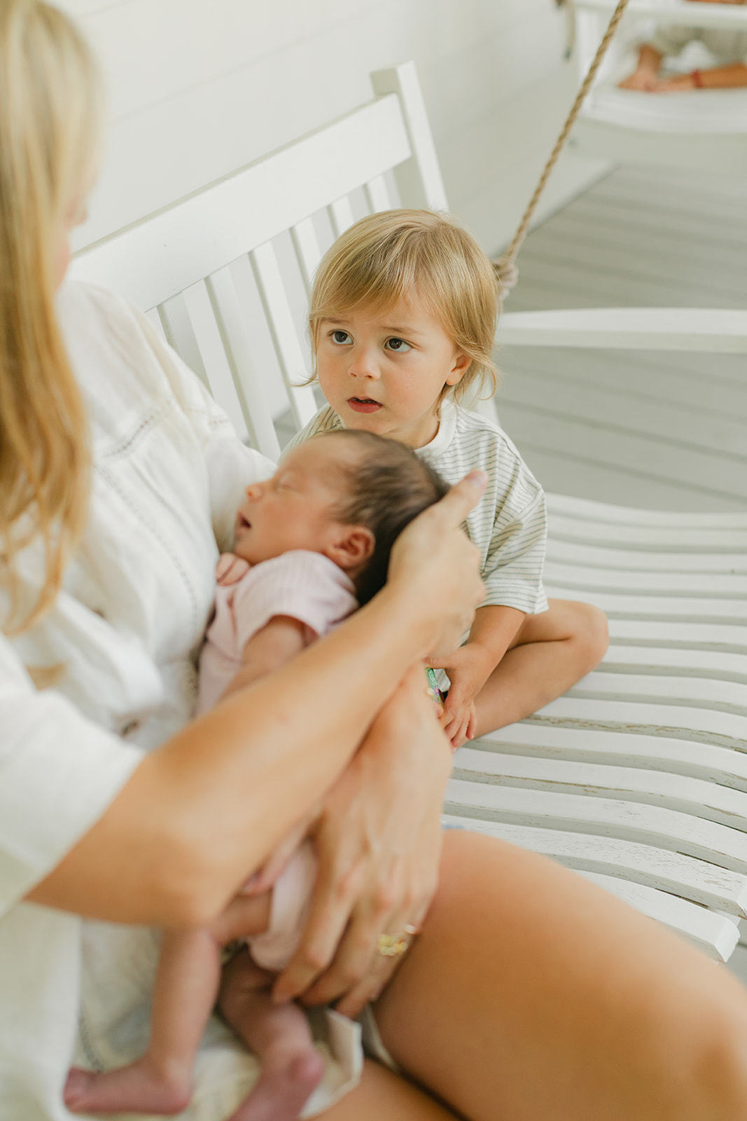 mama with baby and toddler in front porch swing