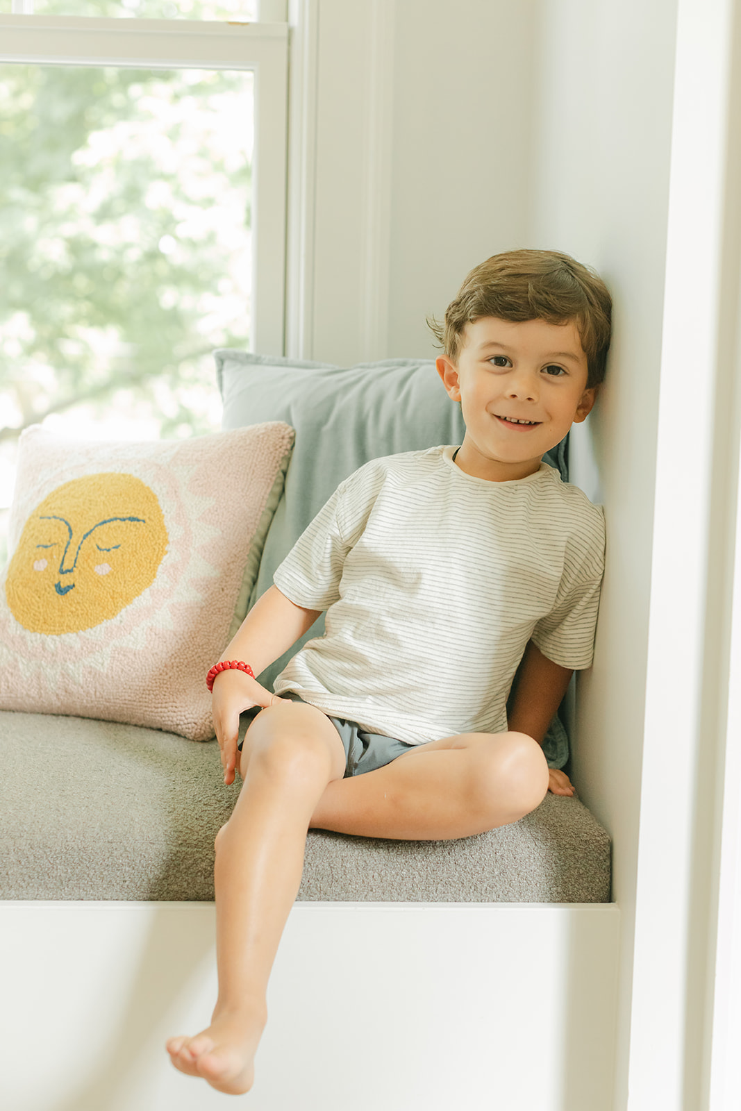 little boy sitting on windowsill