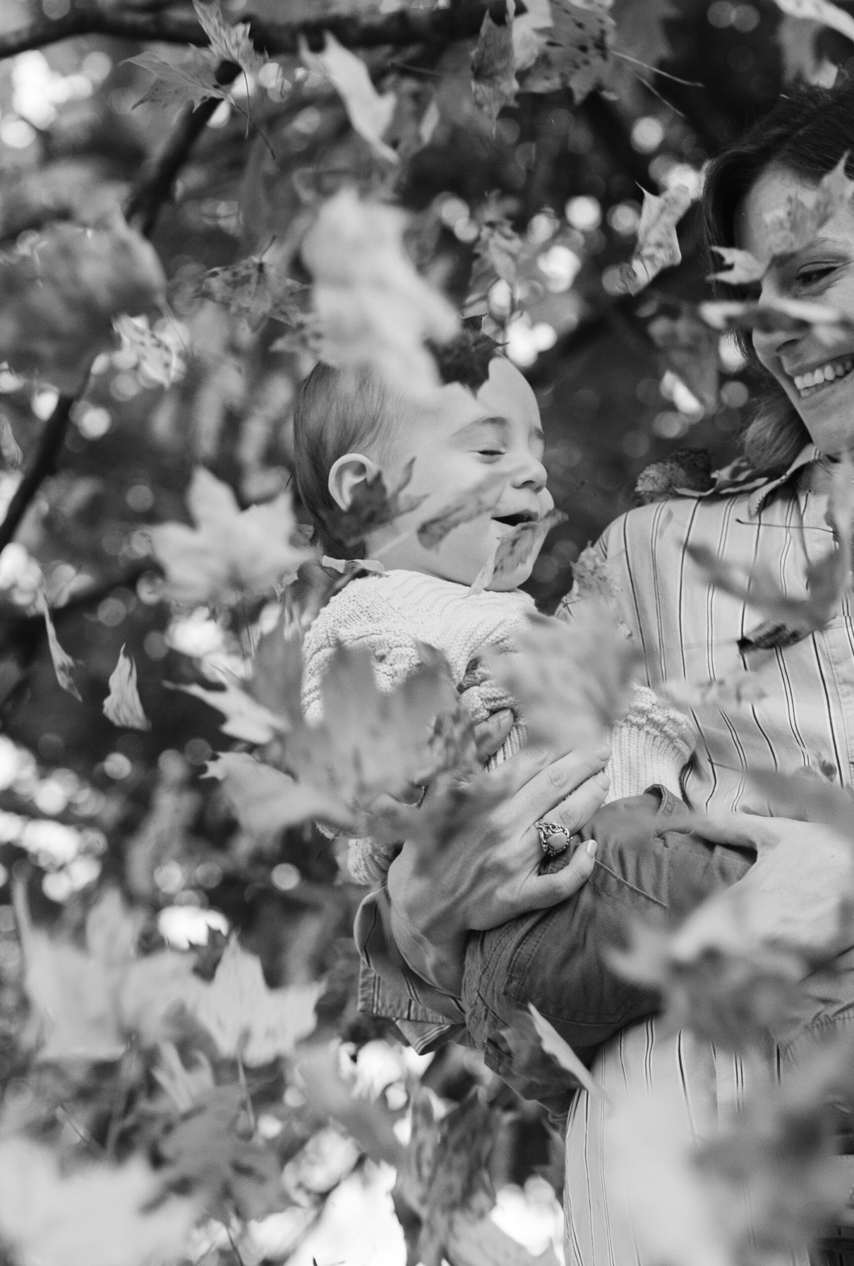 outdoor fall family session. mama and little boy with falling leaves