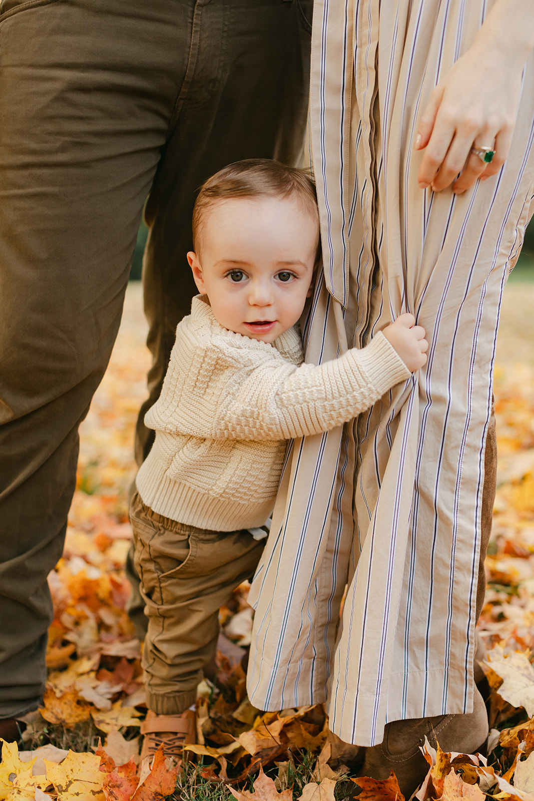 outdoor fall family session. little boy hugging mom's legs