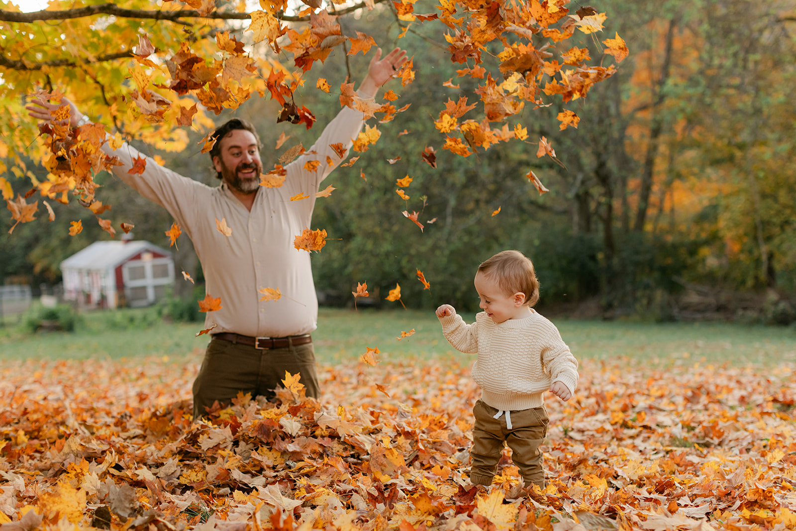 outdoor fall family session. dad and son playing in leaves