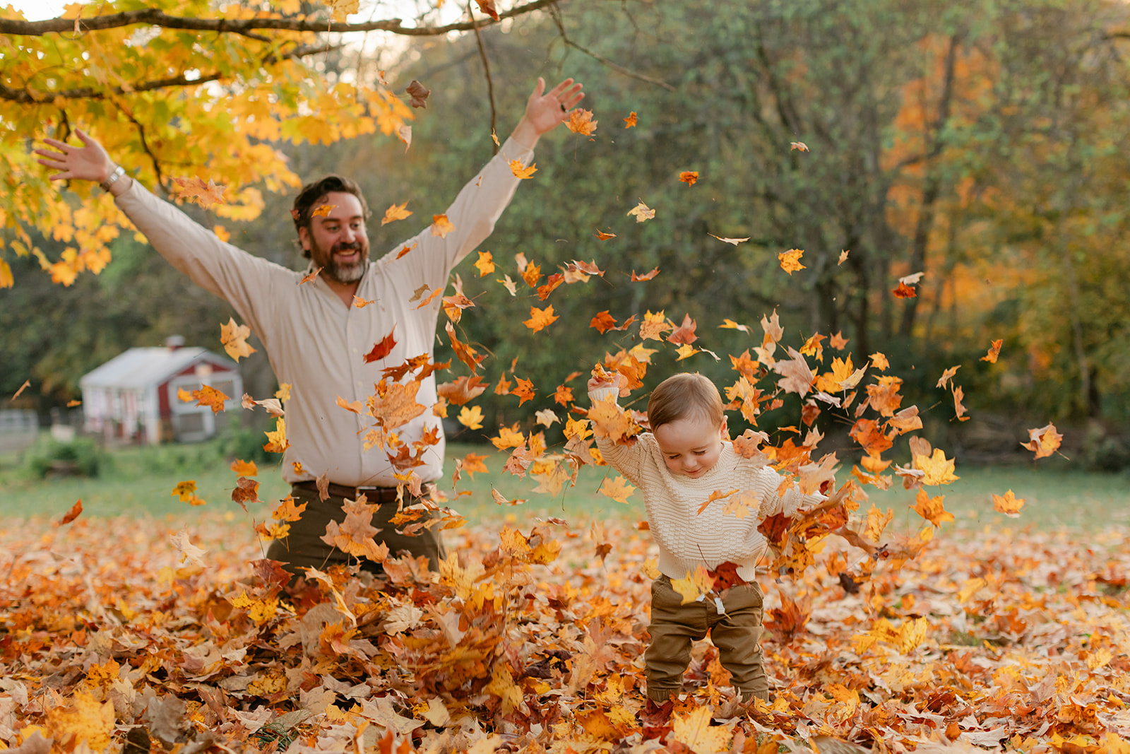 outdoor fall family session. dad and son playing in leaves