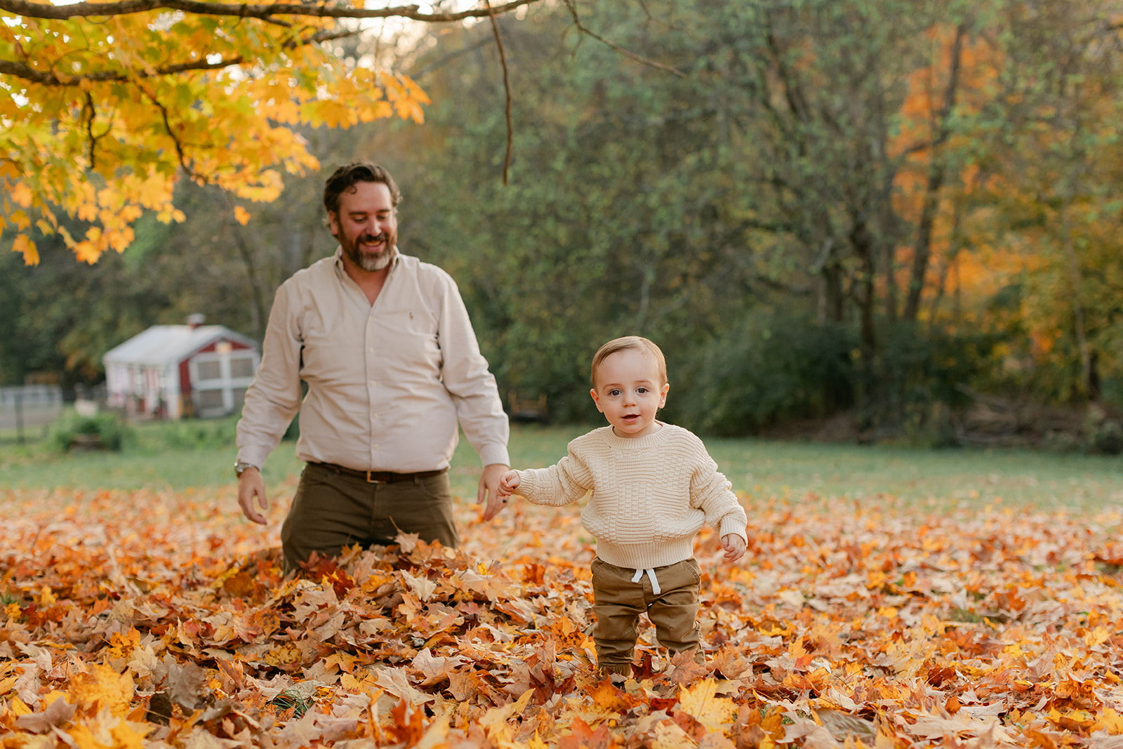 outdoor fall family session. dad and son playing in leaves
