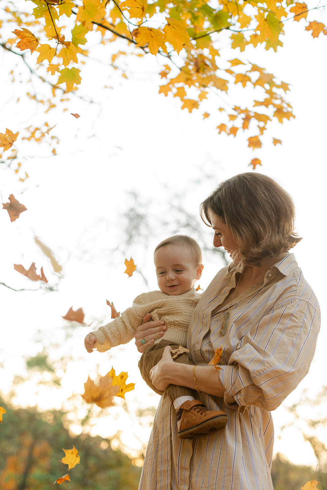 outdoor fall family session. mom and son with falling leaves
