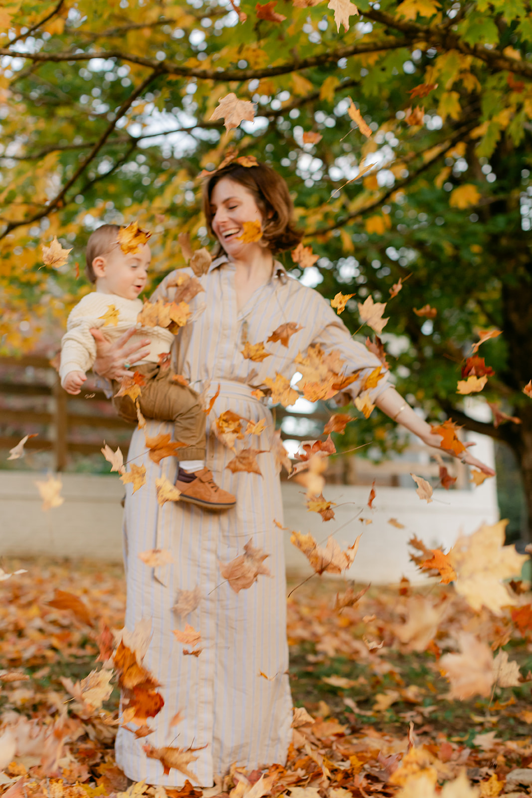 outdoor fall family session. mama playing with leaves with son