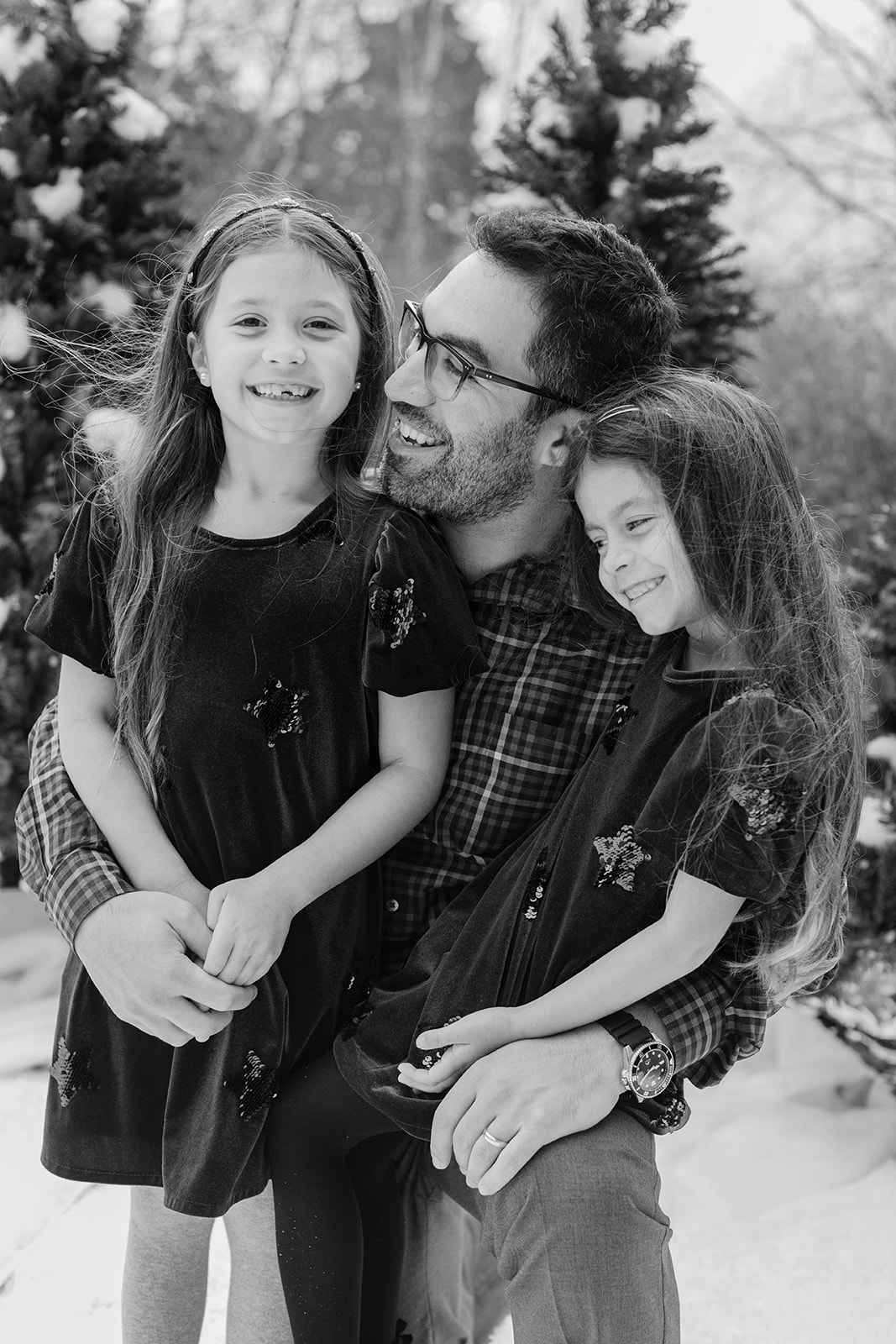 dad and his two daughters. snowy christmas family photos