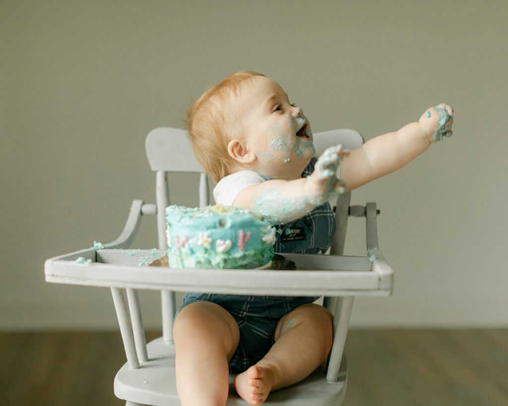 smiling baby boy eating cake