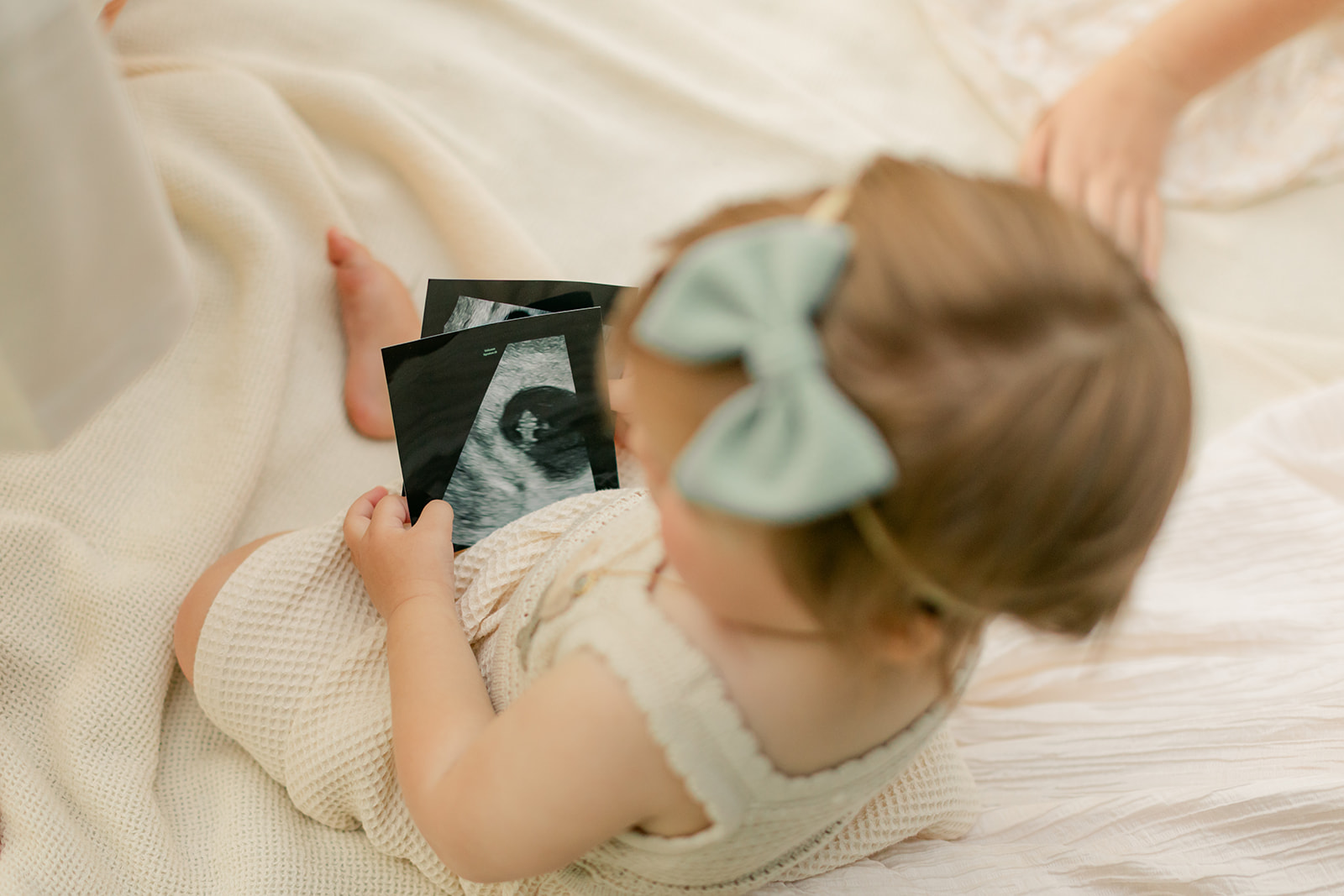 baby girl holding ultrasound photo
