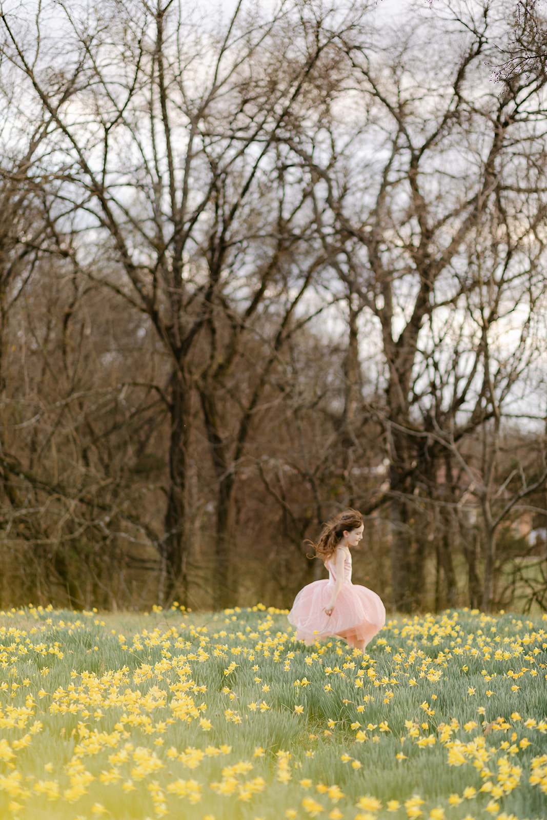 little girl running in daffodil field