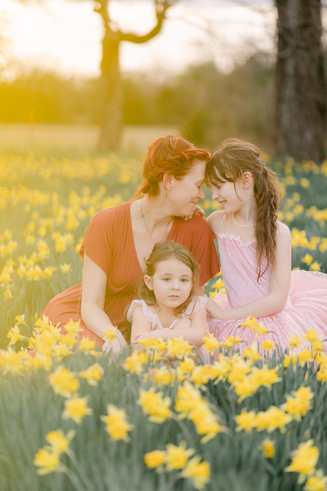 mama and daughters in daffodil field
