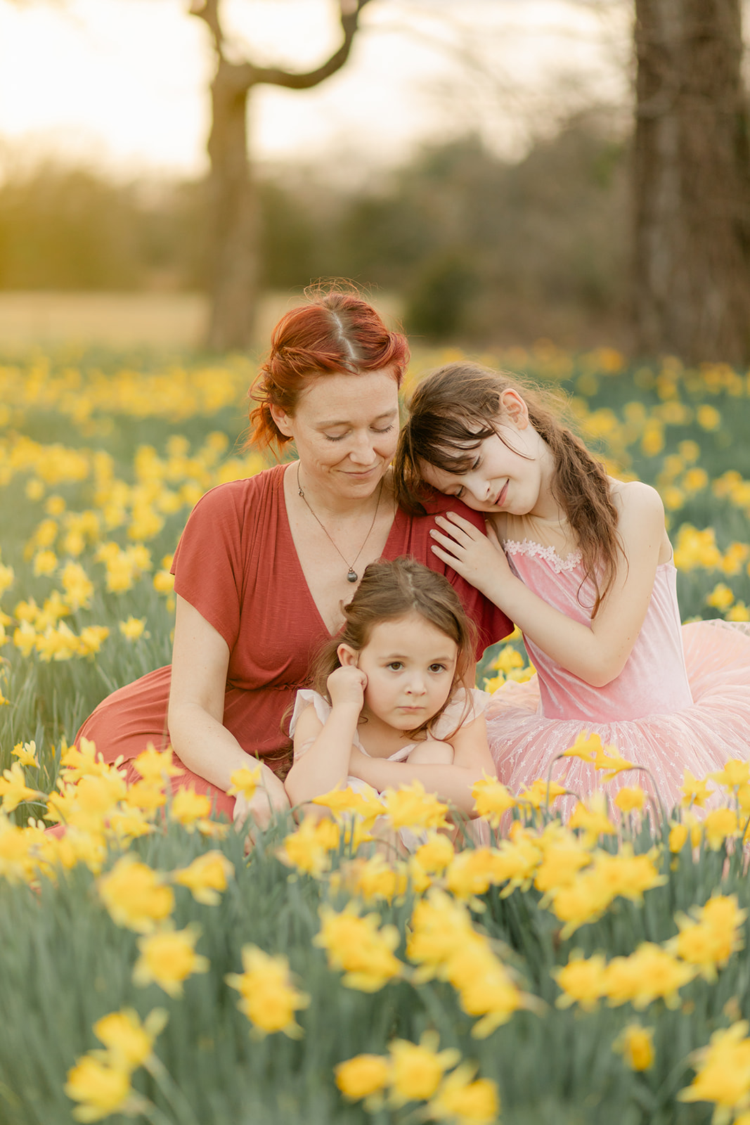 mama and daughters in daffodil field
