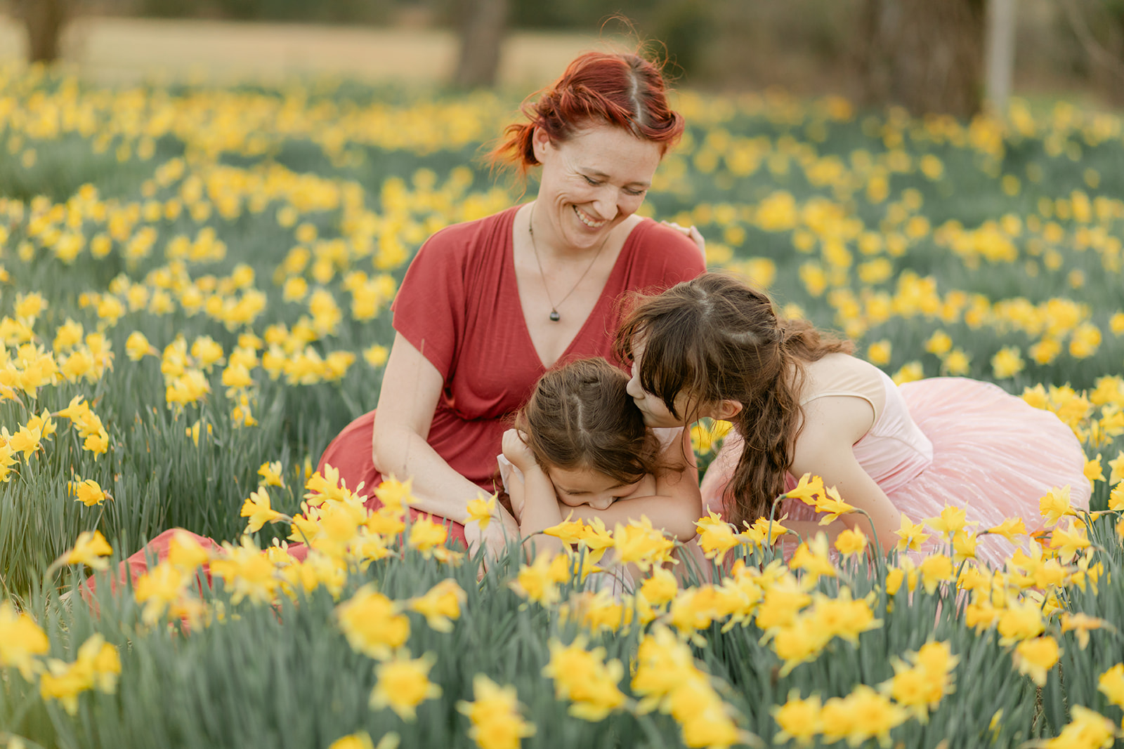 mama and daughters in daffodil field