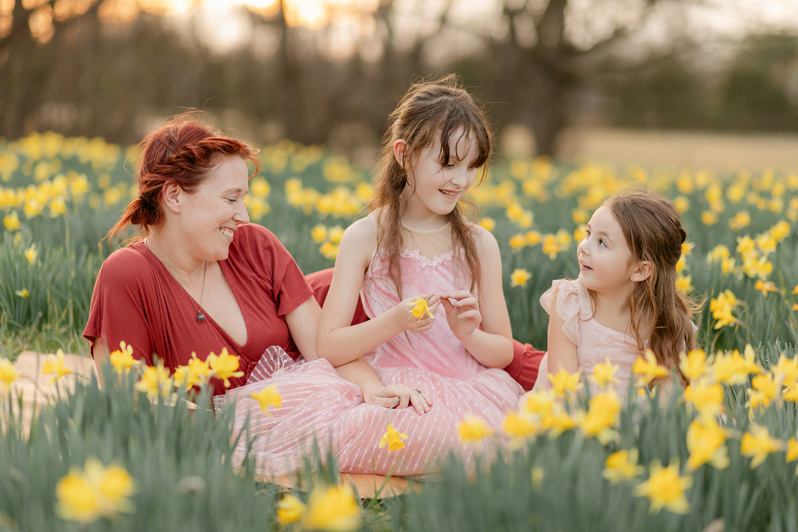 mama and daughters in daffodil field
