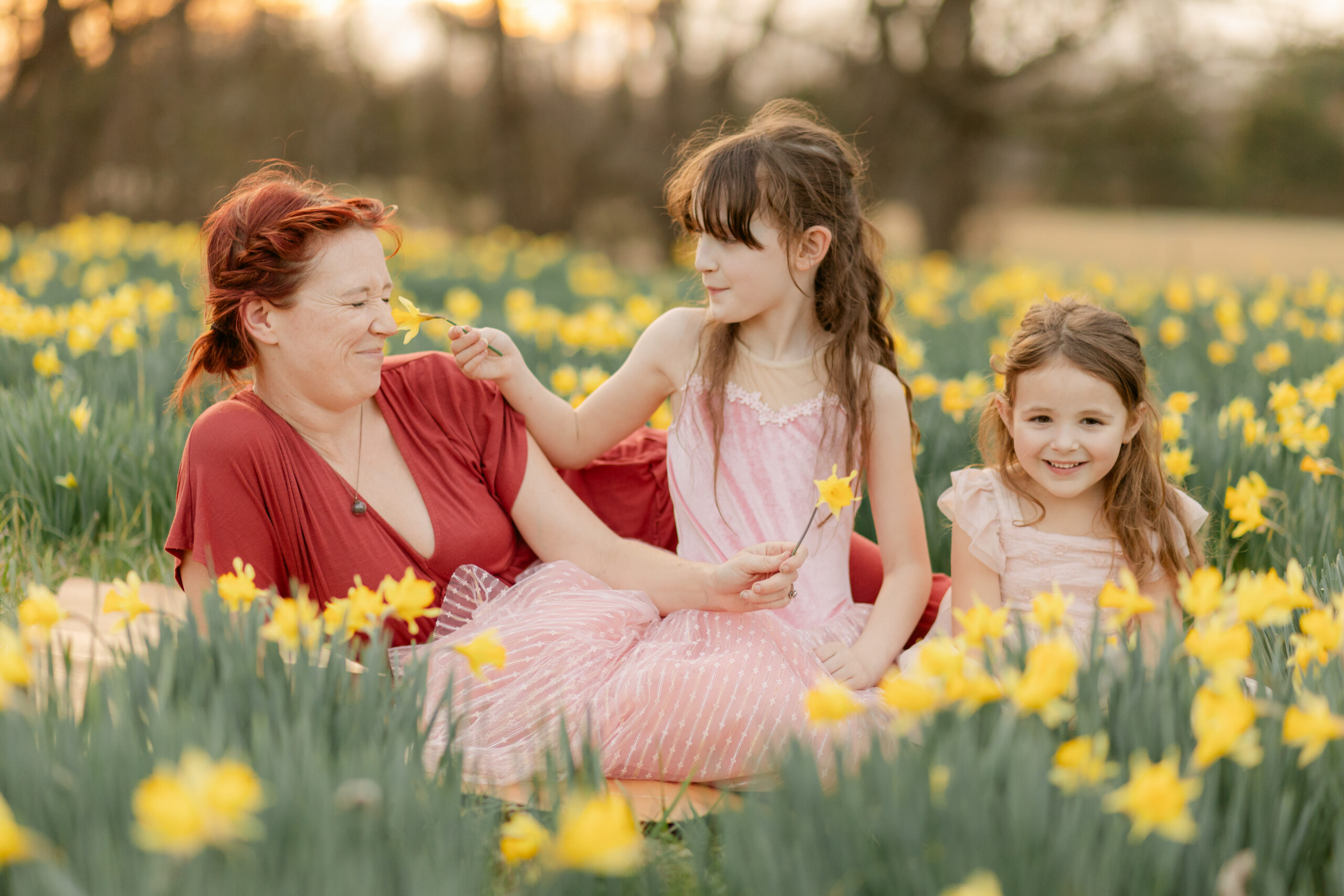 mama and her two daughters in a daffodil field