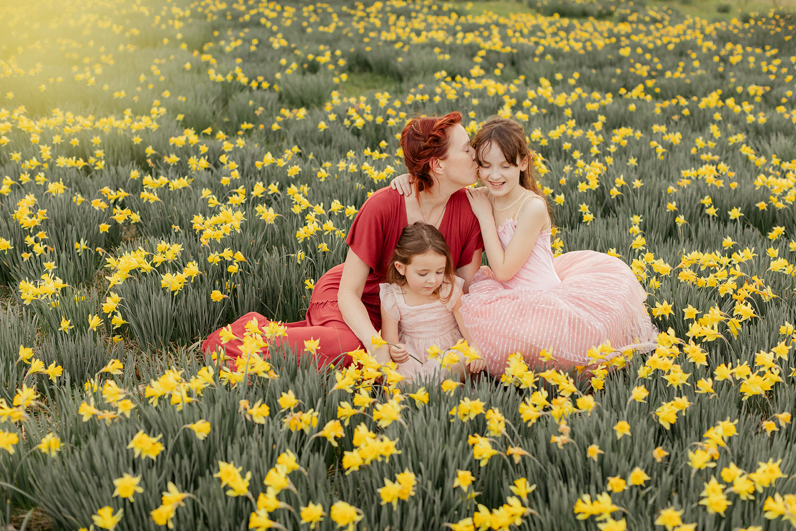 mama and daughters in daffodil field