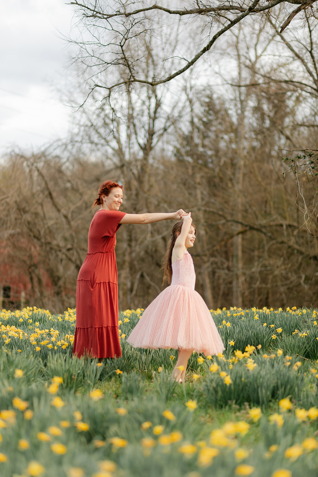 mama and daughter dancing in daffodil field