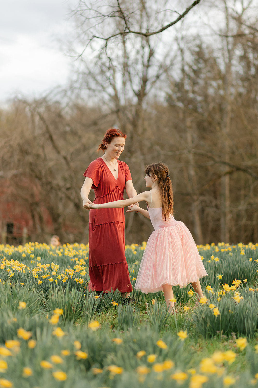 mama and daughter dancing in daffodil field