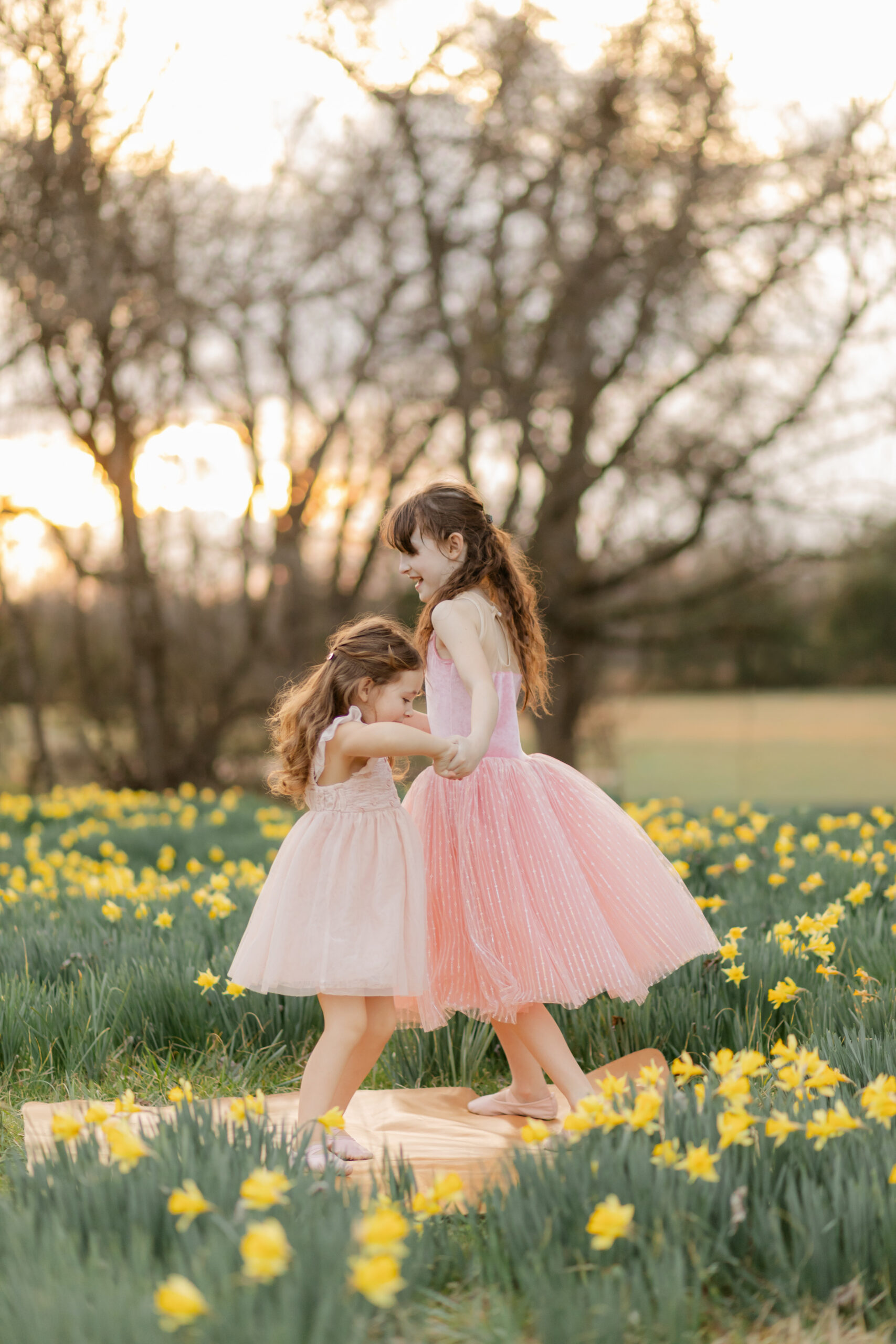 two sisters in matching pink outfits in daffodil field