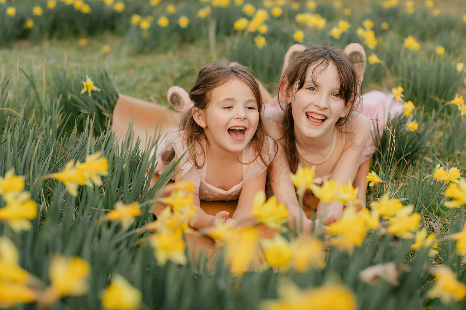 two sisters in matching pink outfits in daffodil field
