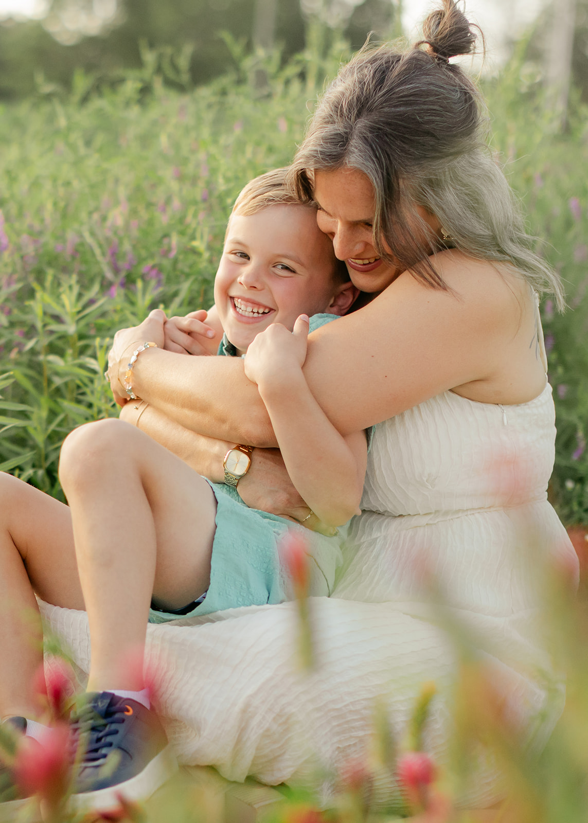 mother hugging son. Outdoor photo session in green field.