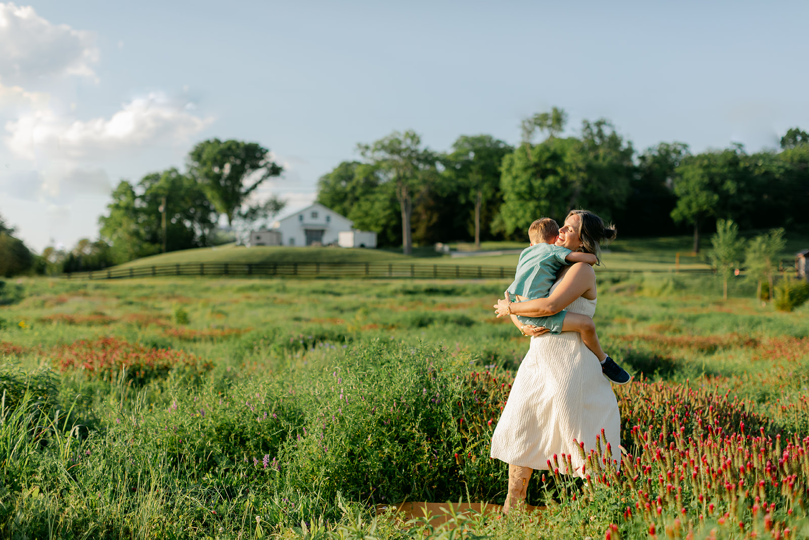 son hugging mom. Outdoor photo session in green field.