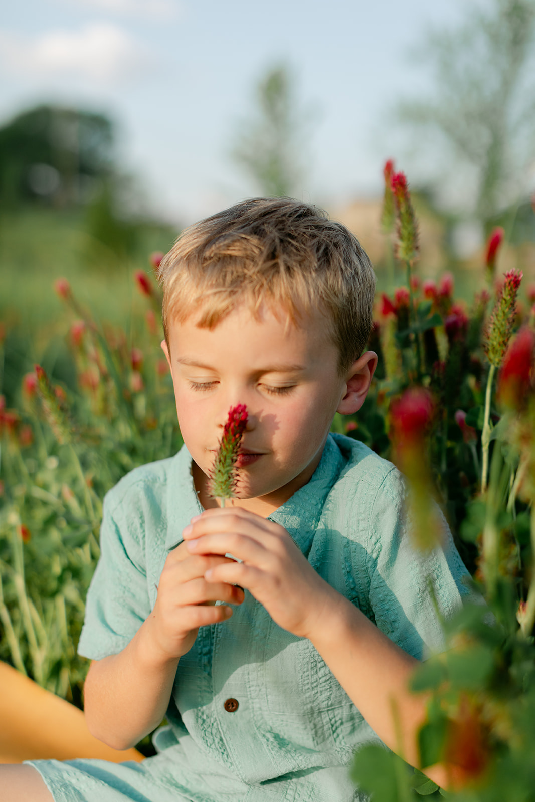 little boy smelling flowers